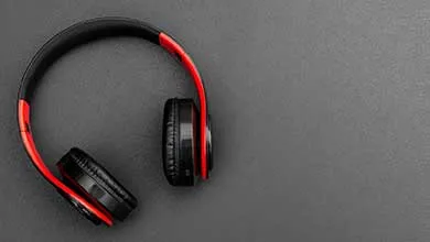 Black and red over-ear headphones on a dark, textured surface.