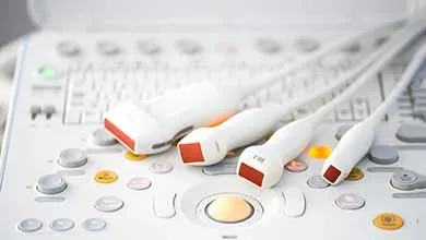 Close-up: Multiple ultrasound probes on a machine's control panel.
